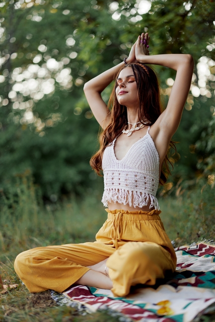 Young woman in crochet top meditating